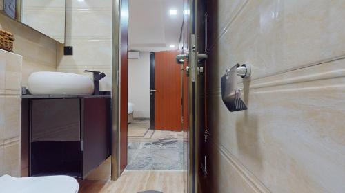 a bathroom with a toilet and a sink and a door at YANNA APARTMENT BY KHALIQUES in Abuja