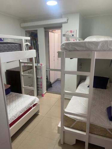 a room with three bunk beds and a hallway at Apartamento Quinto Sector in Viña del Mar