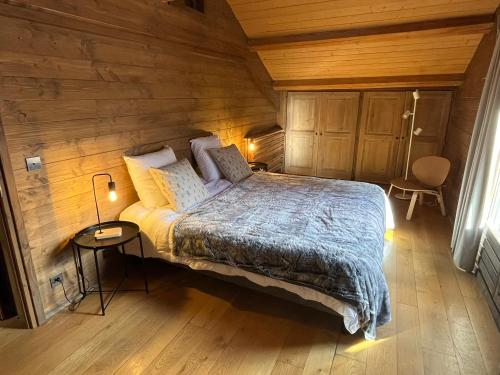 a bedroom with a bed in a wooden cabin at Chalet NANOUK in Le Joseray