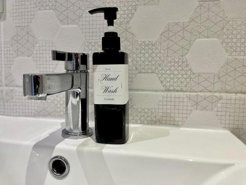 a bottle of hand soap sitting on a sink at Pass the Keys Charming Guest House in St Albans with Parking in St. Albans