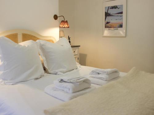 a white bed with towels on top of it at Le Grand Bleu, 1 Court Cottages in Kingsbridge