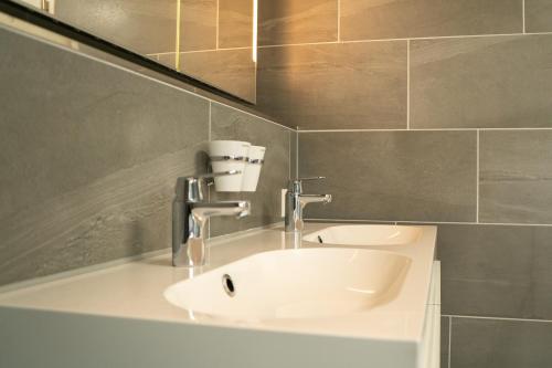 y baño con lavabo blanco y espejo. en Penthouse Visp - mit großer Dachterasse und Panoramablick, en Visp