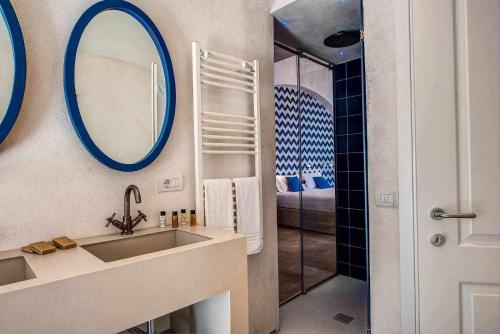 a bathroom with a sink and a mirror and a shower at GOCCE VILLAS - Villa Degli Dei Maestrale in Vico Equense