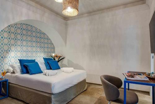 a bedroom with a bed with blue pillows and a table at GOCCE VILLAS - Villa Degli Dei Scirocco in Vico Equense