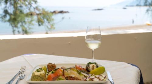 un piatto di cibo e un bicchiere di vino su un tavolo di Testa di Monaco Natural Beach a Capo dʼOrlando