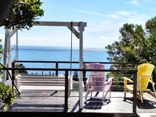 a child sitting on a swing on a porch overlooking the ocean at Sun&Sand Camps Bay in Cape Town