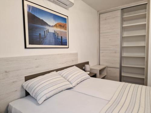 a bedroom with a bed with a picture on the wall at Villa Poseidon in Novalja