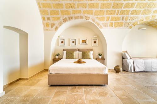 a bedroom with a bed and a stone wall at Villa Brigida Resort in Santeramo in Colle
