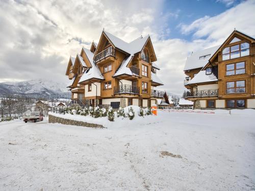 ザコパネにあるVisitZakopane - Tatra Ski Apartmentの雪の大木造家屋
