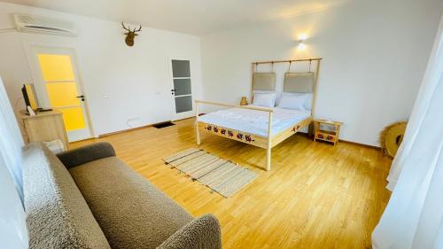 uma sala de estar com uma cama e um sofá em BioLocalia House Oltenia em Baloteşti