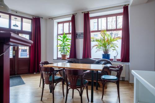 jadalnia z czerwonymi zasłonami oraz stołem i krzesłami w obiekcie Alt-Berliner Eckkneipe - "Feuchte Ecke" w Berlinie