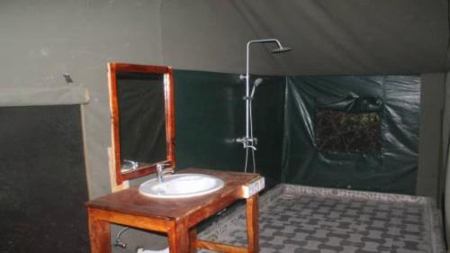 a bathroom with a sink and a mirror at Camp Seluu - Safari Pkg in Kwangwazi