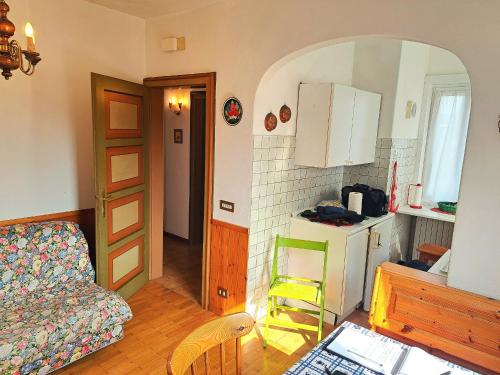uma sala de estar com um sofá e uma cozinha em luminoso ed accogliente, centralissimo appartamento indipendente em Cortina dʼAmpezzo