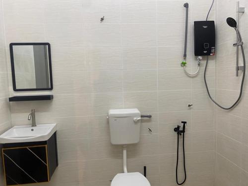 a bathroom with a toilet and a sink and a shower at Homestay Taman Melati Jerantut in Jerantut