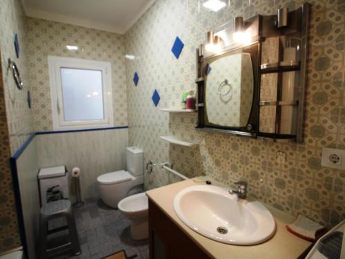 ein Badezimmer mit einem Waschbecken, einem WC und einem Spiegel in der Unterkunft Apartamento Llançà, 2 dormitorios, 4 personas - ES-228-72 in Llança