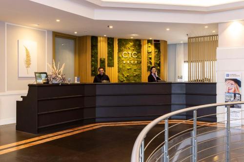 two people standing at a counter in a lobby at Best Western CTC Hotel Verona in San Giovanni Lupatoto