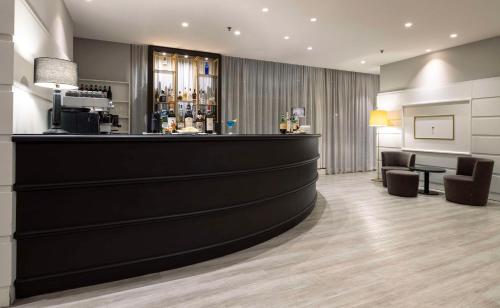 a bar in a hotel with two chairs and a counter at Best Western CTC Hotel Verona in San Giovanni Lupatoto