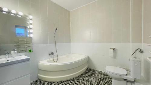 ein weißes Bad mit einem WC und einem Waschbecken in der Unterkunft BioLocalia House Bucovina in Baloteşti