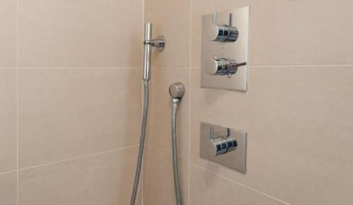 a shower in a bathroom with a shower head at Ribblesdale Retreat in New Southgate