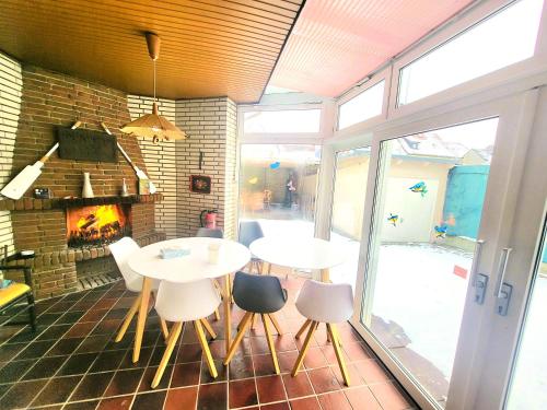 a dining room with two tables and chairs and a fireplace at City Center Hotel Garni Cuxhaven in Cuxhaven