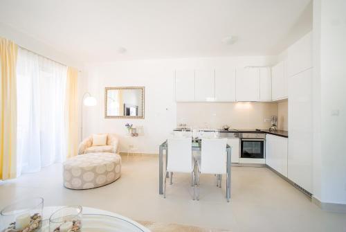 Il comprend une cuisine et un salon avec une table et des chaises. dans l'établissement Lavender Bay Apartment C22, à Kotor