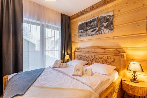 a bedroom with a white bed with a window at Centrum Park 2 Apartament 2 in Szklarska Poręba