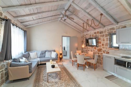 a living room with a couch and a table at AGROTOPIA Guesthouses in Theologos