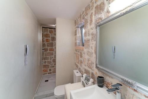 a bathroom with a sink and a mirror at AGROTOPIA Guesthouses in Theologos