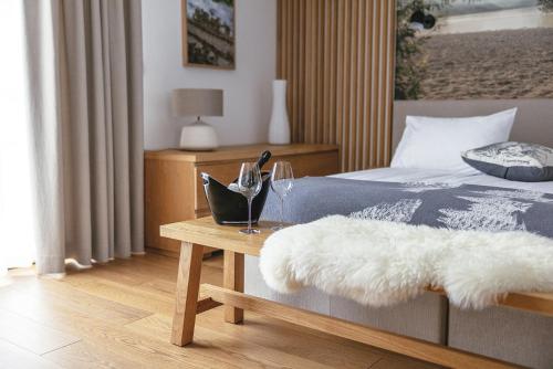 een slaapkamer met een bed en een tafel met wijnglazen bij Hotel Majerca in Bohinj