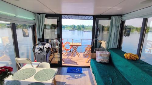 una barca con ponte, divano e tavolo di Houseboat Water Boy apartament pływający dom na wodzie łódź a Uraz