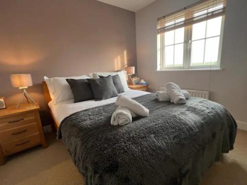 a bedroom with a large bed with two pillows on it at Nollaig Beachside Bliss - Pass the Keys in Rye