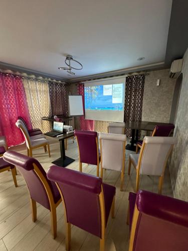 een wachtkamer met stoelen en een projectiescherm bij Comfort Hotel Orléans Olivet in Olivet