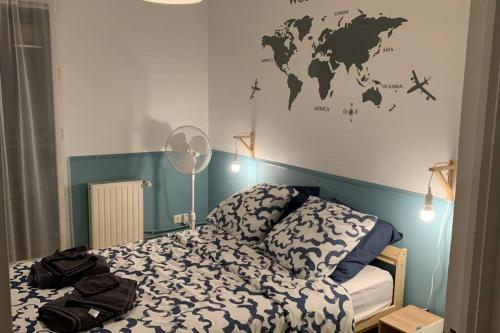 a bedroom with a bed with a map of the world on the wall at Cœur de ville Loverien in Louviers