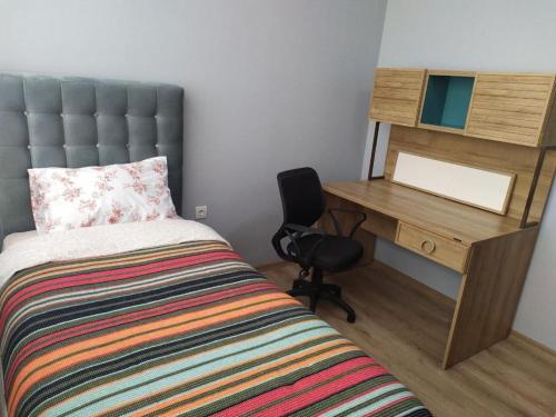 a bedroom with a bed and a desk and a chair at Flat near the sea in Erdemli