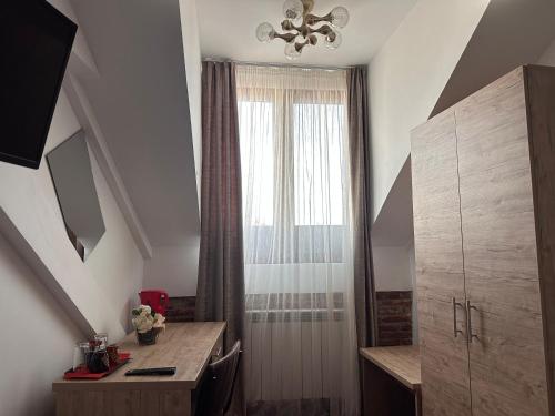 a room with a desk and a window with a curtain at Pensiunea SADA in Făgăraş