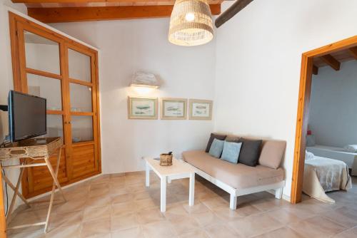 a living room with a couch and a tv at Cas Saliners - Ses Illetes in La Savina