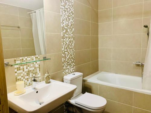 y baño con aseo, lavabo y bañera. en Lavender Bay Apartment D9, en Donji Morinj
