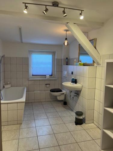 La salle de bains est pourvue d'une baignoire, d'un lavabo et de toilettes. dans l'établissement Gästewohnung Eberswalde, à Eberswalde