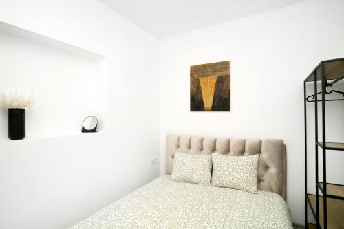 a bedroom with a bed and a painting on the wall at Central Station Apartment No7 in Kaunas