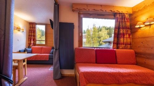 a living room with a couch and a window at les arcades a37 4 pers in Doucy