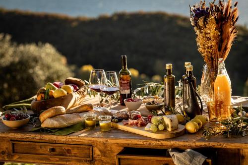 a table filled with food and bottles of wine at Colago Private Villas Lake Garda in Toscolano Maderno