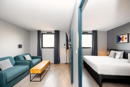 マルセイユにあるStaycity Aparthotels Marseille Centre Vieux Portのベッドとソファ付きのホテルルーム