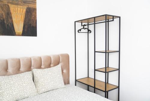 a bedroom with a bed and a black book shelf at Central Station Apartment No7 in Kaunas