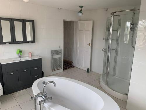 a bathroom with a tub and a shower and a sink at Wellbet Farm in Swinderby