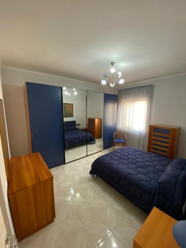 um quarto com uma grande cama azul e um espelho em Alloggio Salice em Acerra