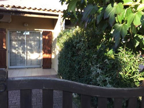 un banc en bois assis devant une maison dans l'établissement Belle maison T2 Mezzanine, au Barcarès