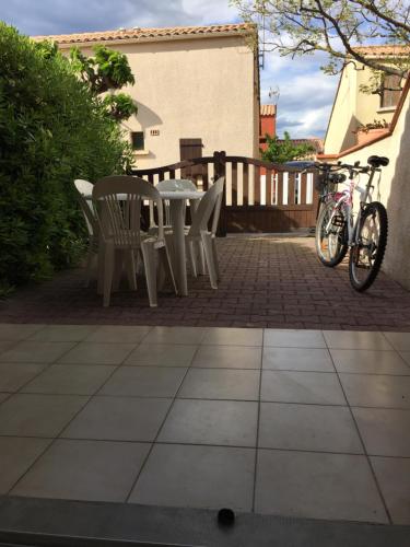 - une table, des chaises et un vélo sur la terrasse dans l'établissement Belle maison T2 Mezzanine, au Barcarès