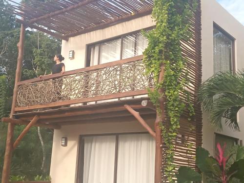 a woman standing on a balcony of a house at Villa AHAL, in Chemuyil