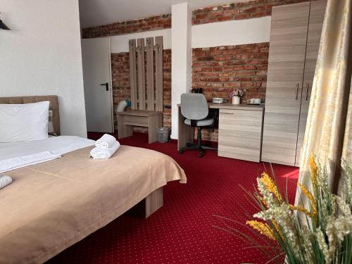 a hotel room with a bed and a desk at Pensiunea SADA in Făgăraş