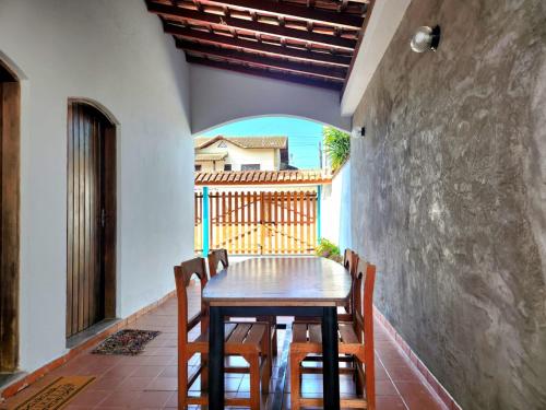 uma mesa e cadeiras num quarto com uma varanda em Casa no Centro 600m da Praia em Bertioga
